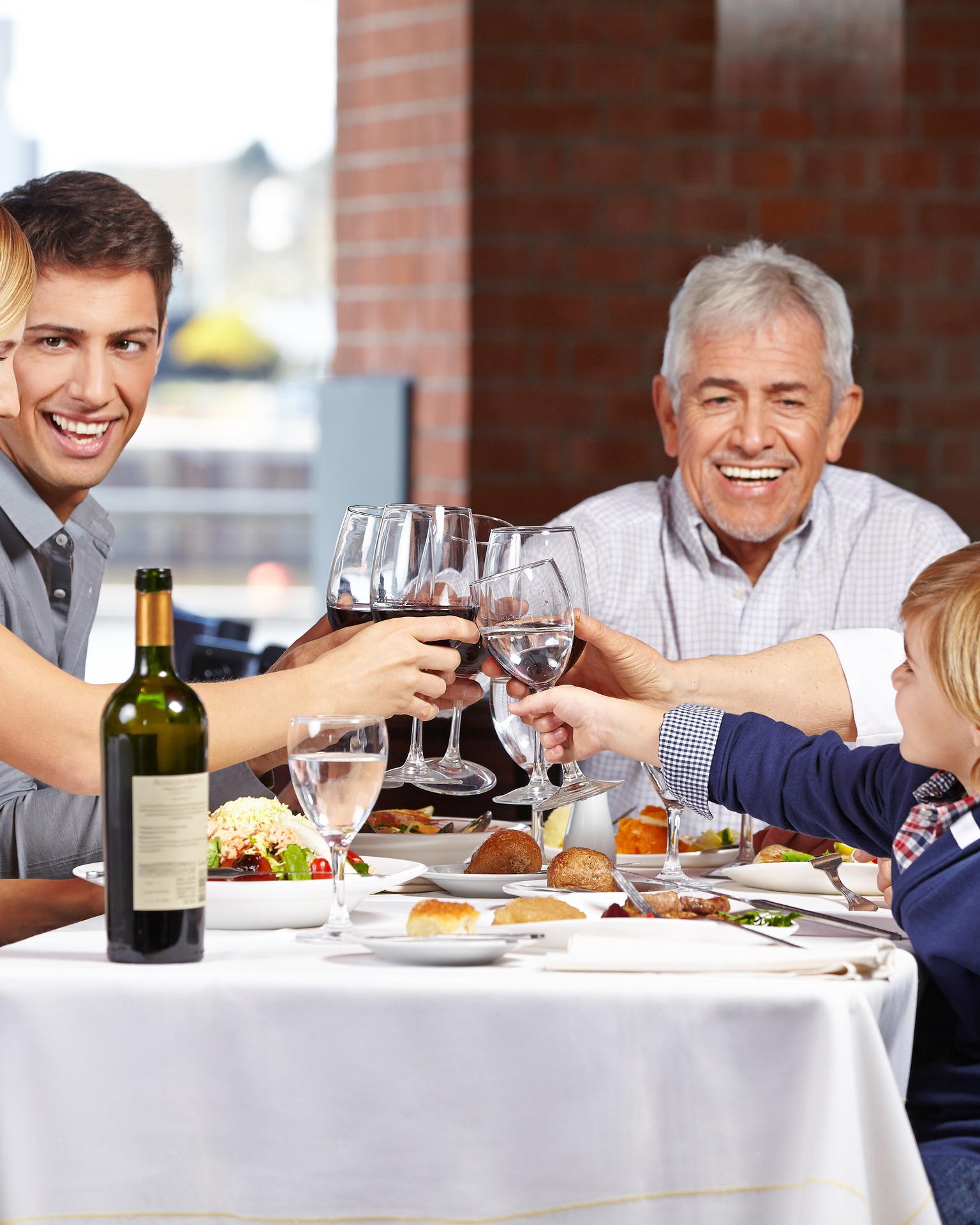 Familie im Restaurant prostet sich gegenseitig zu